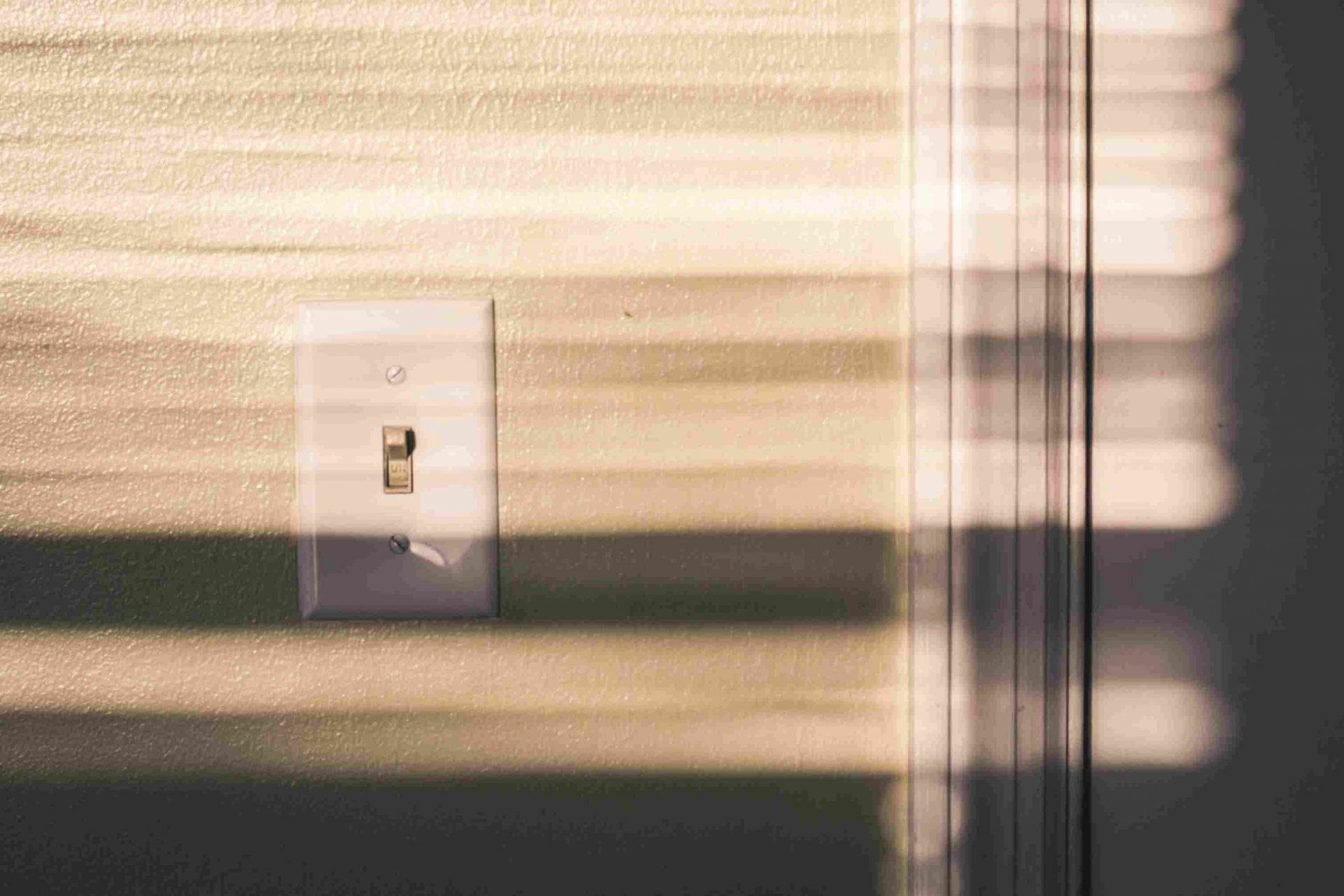 A light switch in a room at dusk.