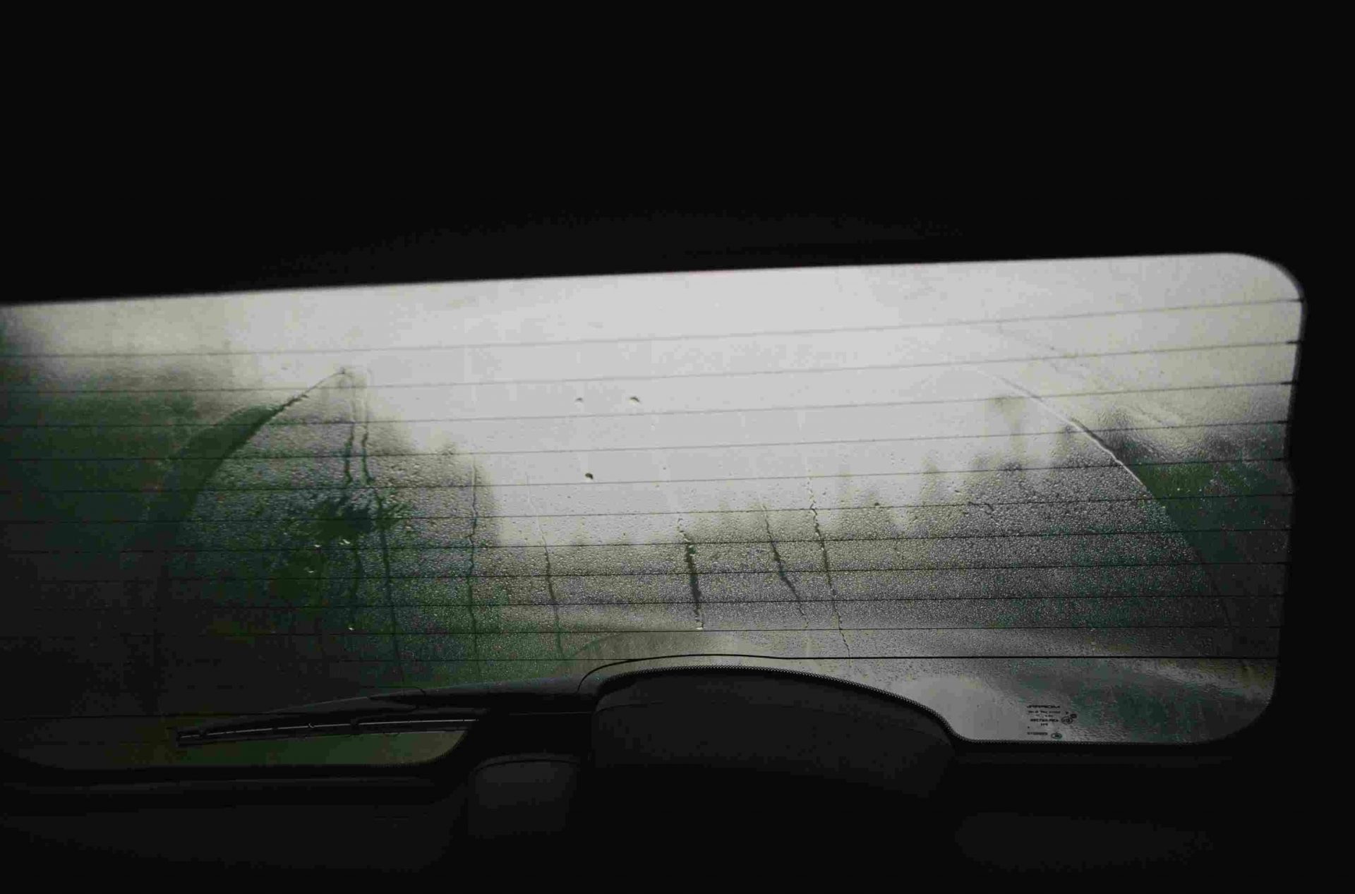 The rear window of a car covered in mist.